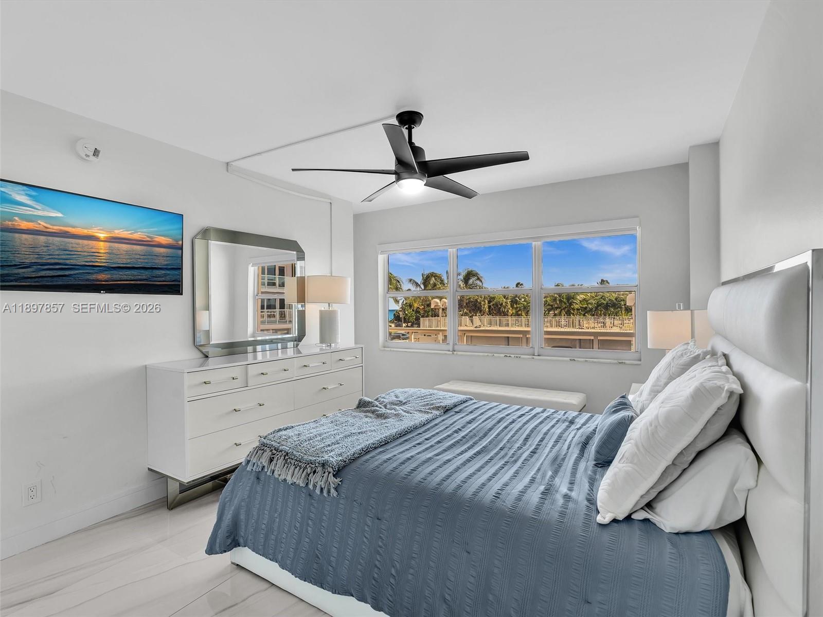 111 North Pompano Beach Boulevard, Unit 308 Pompano Beach, FL 33062 - Photo 21 of 50 a bedroom with a large bed and a chandelier