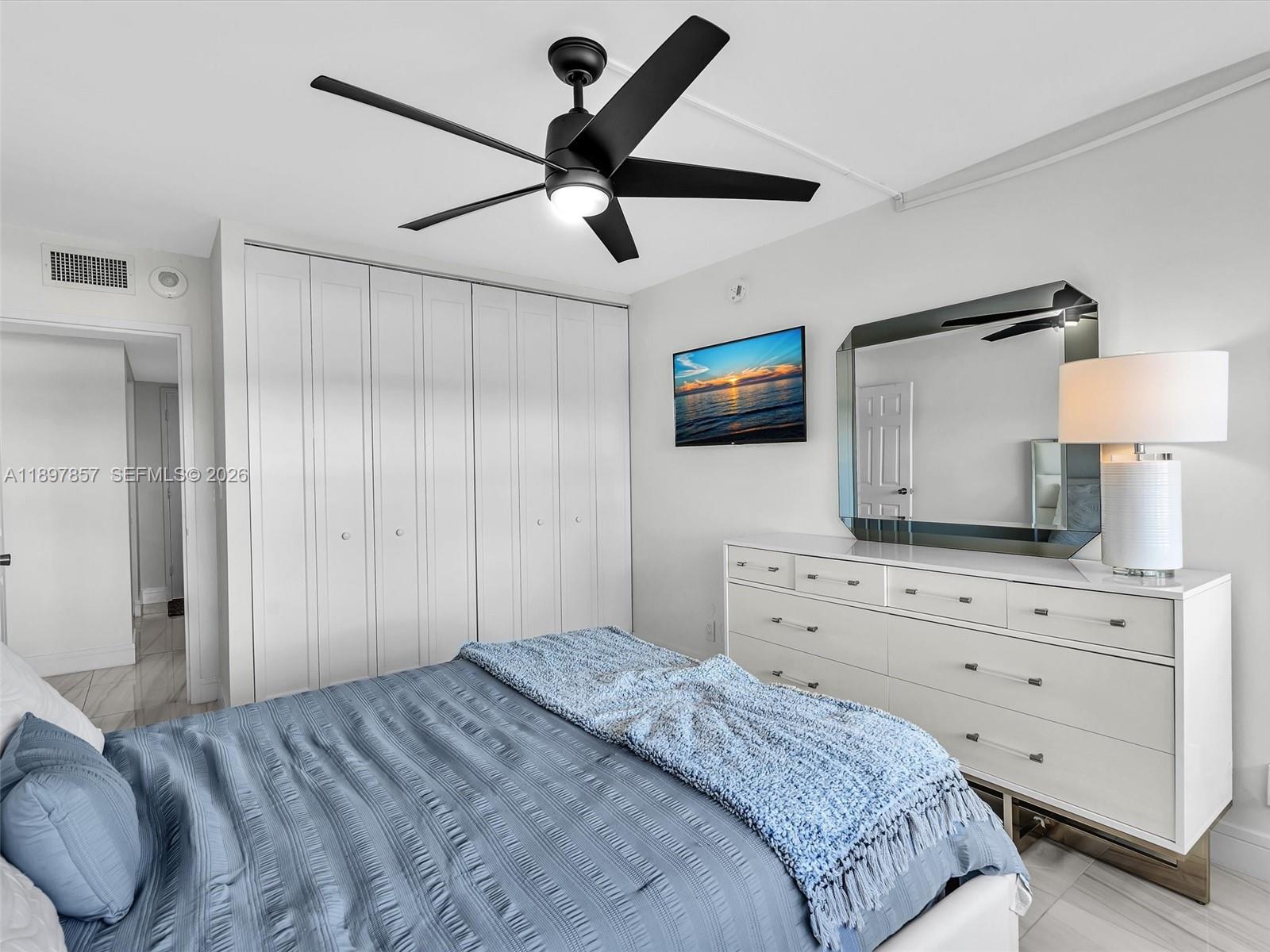 111 North Pompano Beach Boulevard, Unit 308 Pompano Beach, FL 33062 - Photo 22 of 50 a bedroom with a large bed and a flat tv screen on dresser