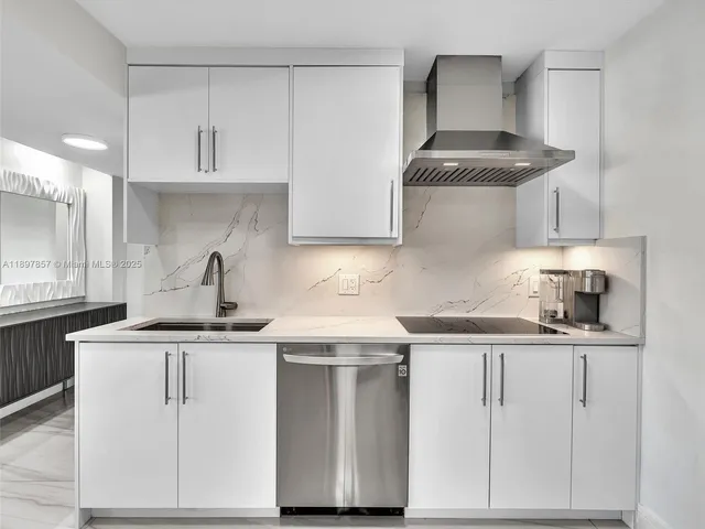 a kitchen with white cabinets appliances and sink