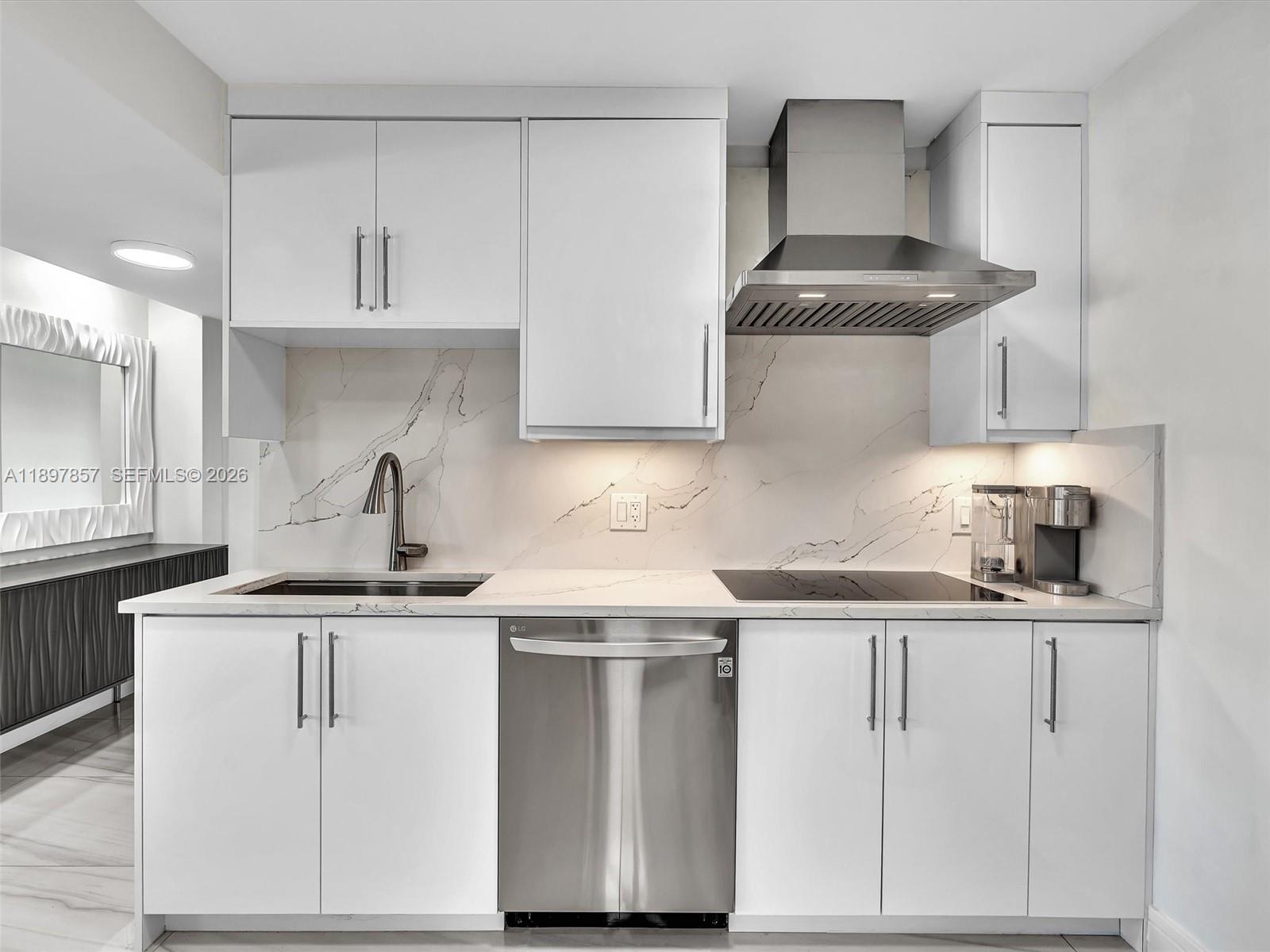 111 North Pompano Beach Boulevard, Unit 308 Pompano Beach, FL 33062 - Photo 7 of 50 a kitchen with white cabinets appliances and sink
