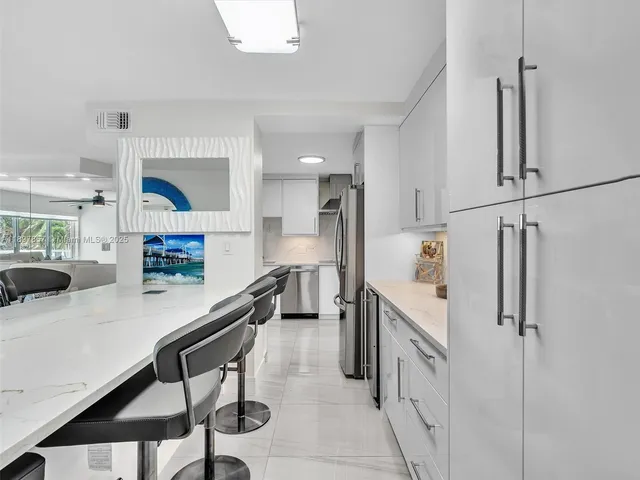 a kitchen with stainless steel appliances cabinets and a table