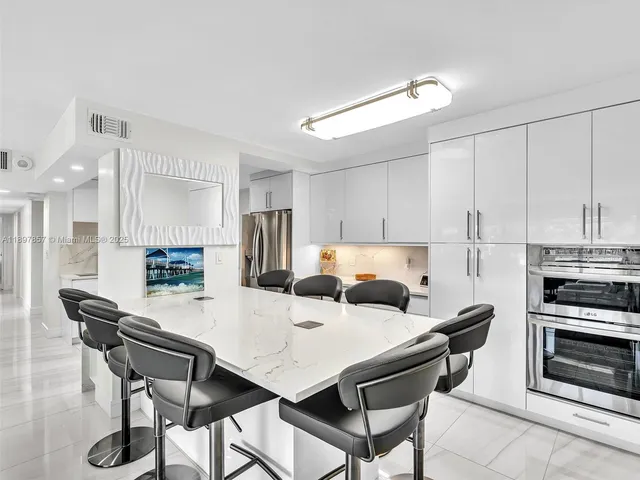 a kitchen with a table chairs a sink dishwasher and cabinets