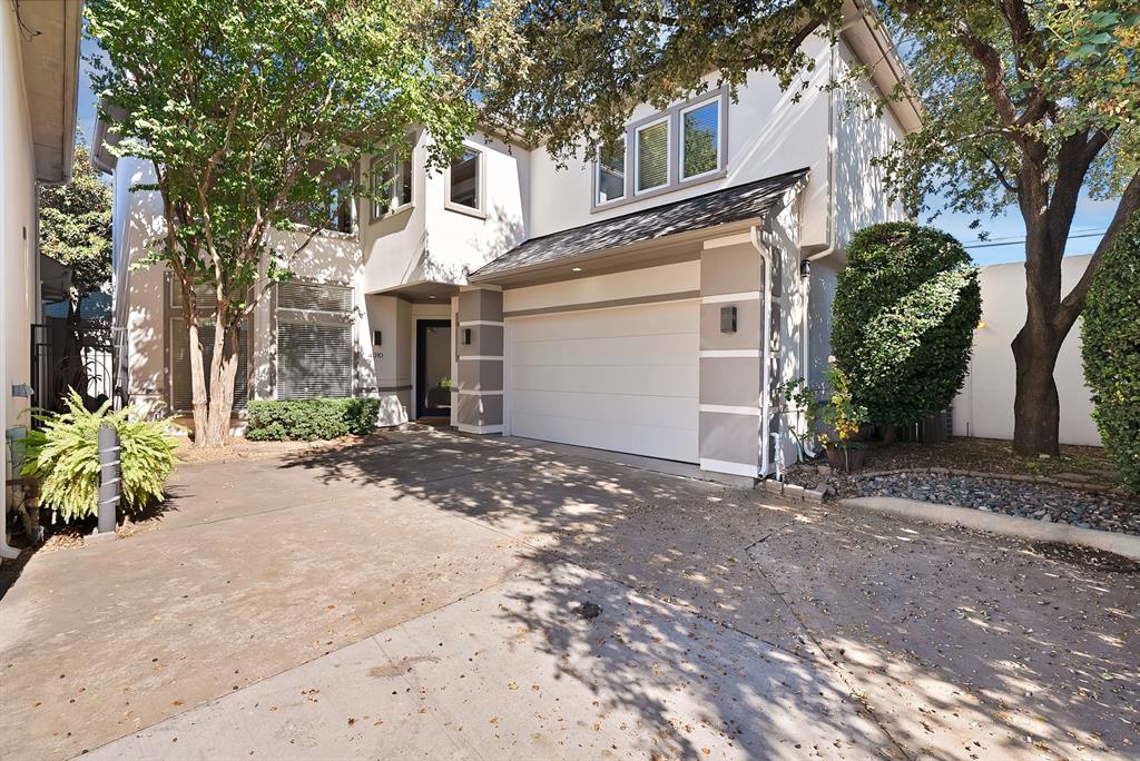 View of front facade featuring an attached garage, stucco siding, and concrete driveway
