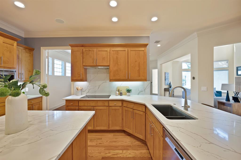 4010 Rawlins Street Dallas, TX 75219 - Photo 13 of 40 Kitchen featuring light stone counters, light wood-style flooring, ornamental molding, stainless steel dishwasher, and recessed lighting