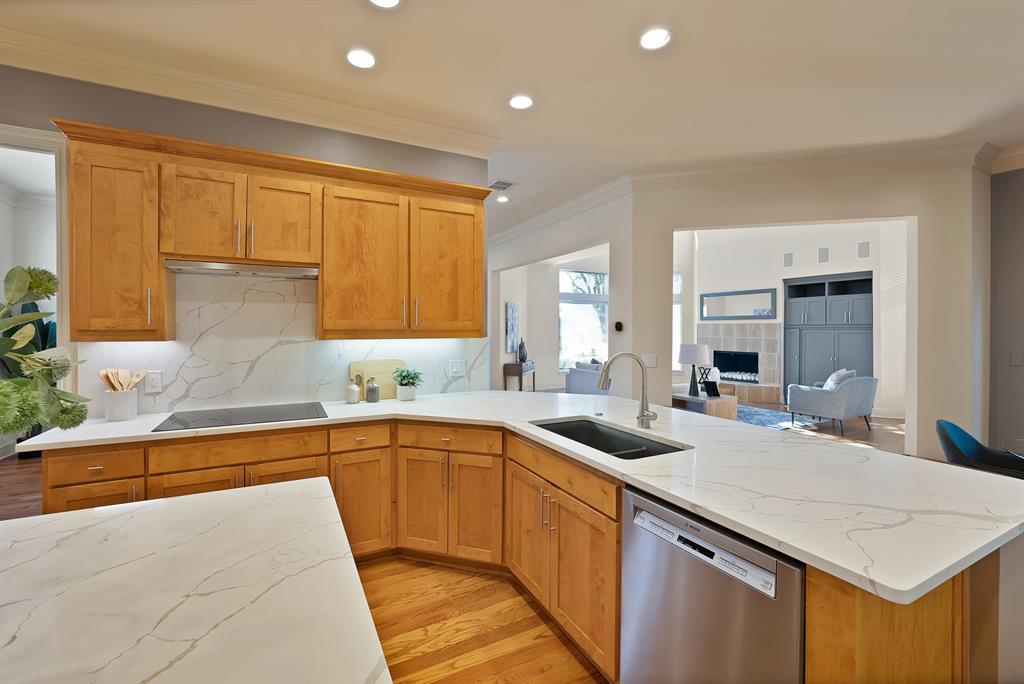 4010 Rawlins Street Dallas, TX 75219 - Photo 19 of 40 Kitchen with stainless steel dishwasher, light stone counters, ornamental molding, light wood-type flooring, and recessed lighting