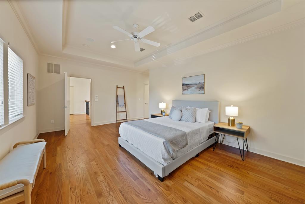 4010 Rawlins Street Dallas, TX 75219 - Photo 25 of 40 Bedroom with crown molding, light wood finished floors, a ceiling fan, and a tray ceiling