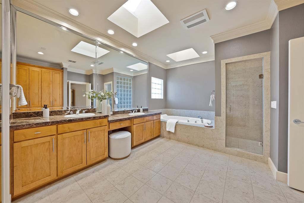 4010 Rawlins Street Dallas, TX 75219 - Photo 35 of 40 Full bathroom with a stall shower, vanity, a garden tub, a skylight, and crown molding