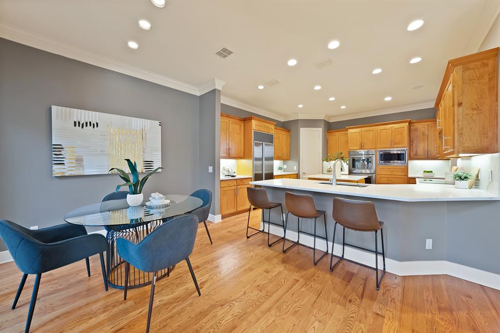 4010 Rawlins Street Dallas, TX 75219 - Photo 9 of 40 Kitchen with a kitchen breakfast bar, a peninsula, light wood-style flooring, recessed lighting, and built in appliances