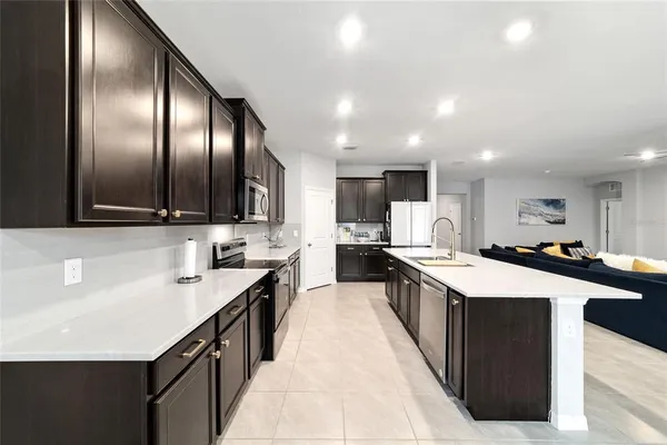a large kitchen with stainless steel appliances a sink and cabinets