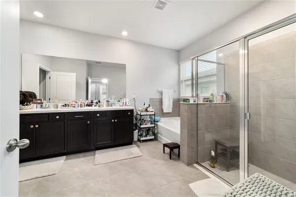 a spacious bathroom with a double vanity sink a mirror and shower