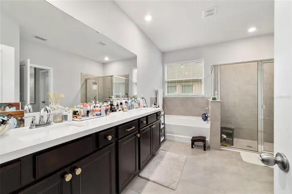 a spacious bathroom with a double vanity sink a mirror and a bathtub