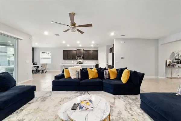 a living room with furniture kitchen and a chandelier