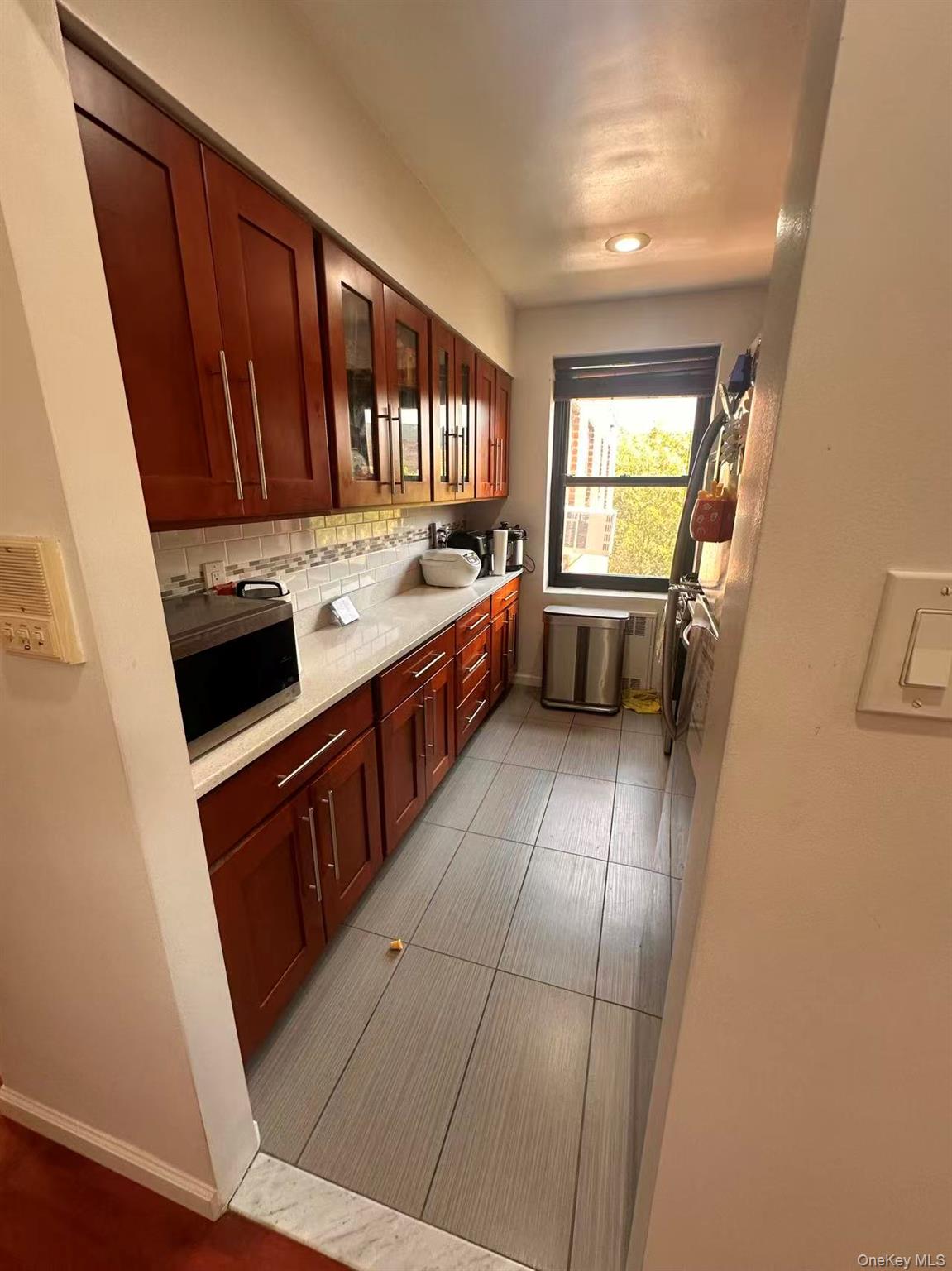 139-15 28th Road, Unit 6G Queens, NY 11354 - Photo 19 of 20 a kitchen with a sink stove and cabinets