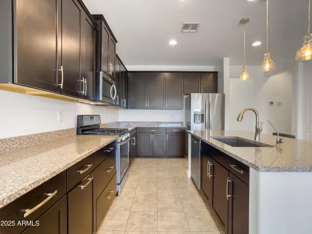 a kitchen with a sink refrigerator and cabinets