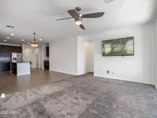an empty room with window and ceiling fan