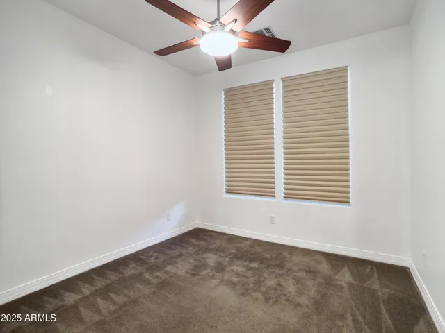an empty room with a chandelier fan