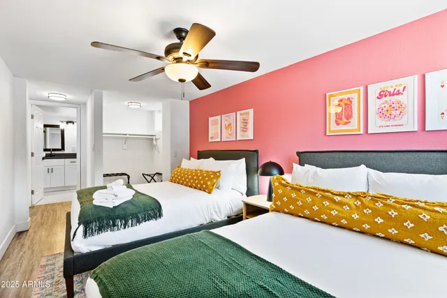 a bedroom with two beds and a chandelier