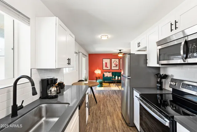 a kitchen with stainless steel appliances a sink a stove and cabinets