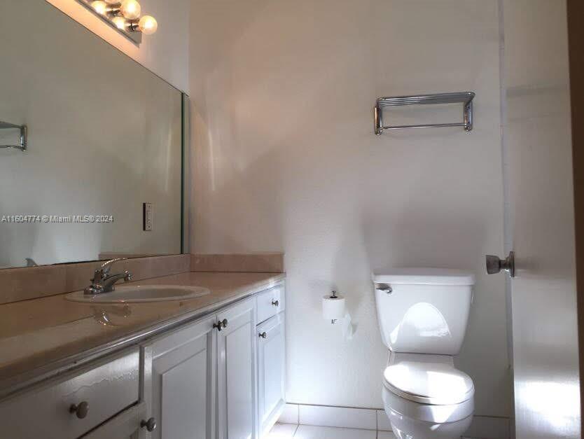 123 Southwest 17th Road, Unit 103 Miami, FL 33129 - Photo 14 of 21 a bathroom with a granite countertop sink a toilet and a mirror