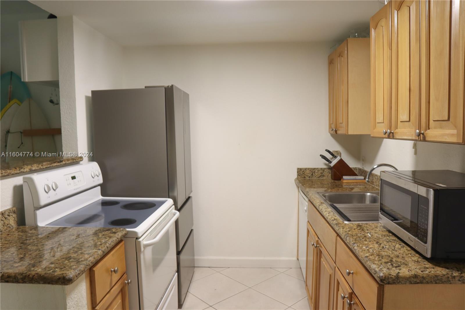 123 Southwest 17th Road, Unit 103 Miami, FL 33129 - Photo 4 of 21 a kitchen with stainless steel appliances granite countertop a refrigerator stove and sink