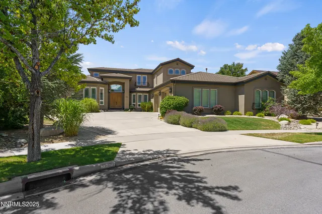 a front view of a house with a yard and trees