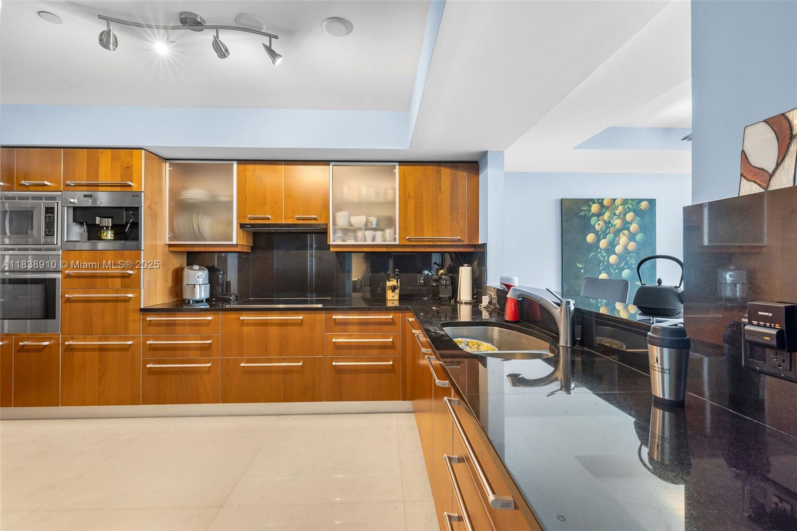 1331 Brickell Bay Drive, Unit 2909 Miami, FL 33131 - Photo 13 of 48 a living room with stainless steel appliances kitchen island granite countertop a table chairs in it and a flat screen tv