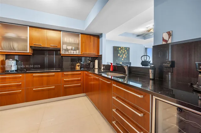 a view of a kitchen with stainless steel appliances granite countertop a sink and a refrigerator