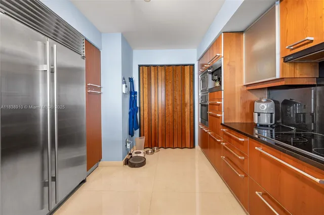 a kitchen with stainless steel appliances granite countertop a refrigerator and a stove top oven