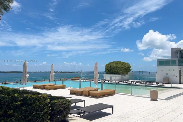 a view of a swimming pool with a patio and dining table