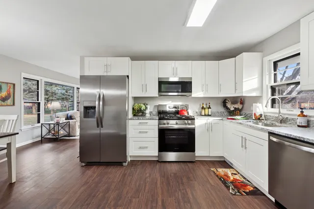 a kitchen with stainless steel appliances granite countertop a refrigerator stove and sink