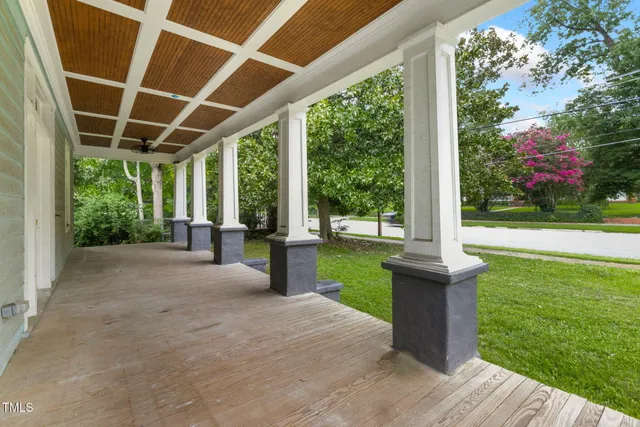 a view of a patio with couches plants and large tree