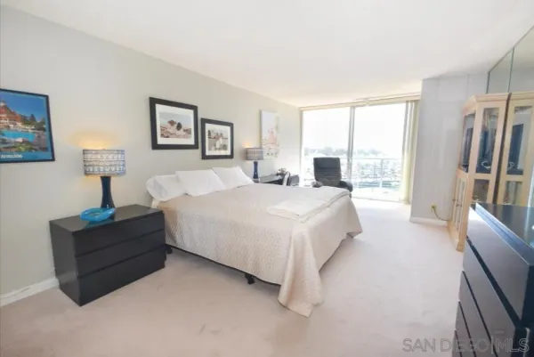 a spacious bedroom with a bed and a painting on the wall