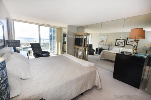 a bedroom with a bed and large window