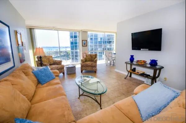 a living room with furniture a flat screen tv and a floor to ceiling window