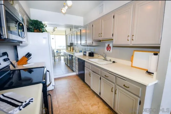 a kitchen with stainless steel appliances sink stove microwave and cabinets