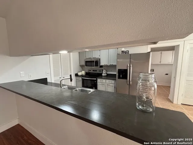 a kitchen with stainless steel appliances granite countertop a sink a stove and a refrigerator