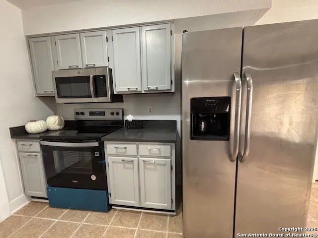 a kitchen with stainless steel appliances a stove a microwave and a refrigerator
