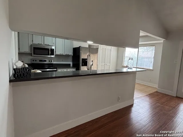 a kitchen with stainless steel appliances a sink a microwave a refrigerator and cabinets