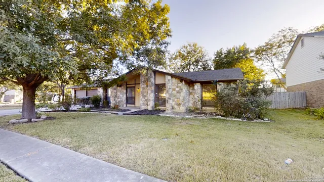a front view of a house with a garden and tree