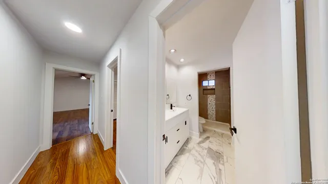 a view of an empty room with wooden floor and cabinets