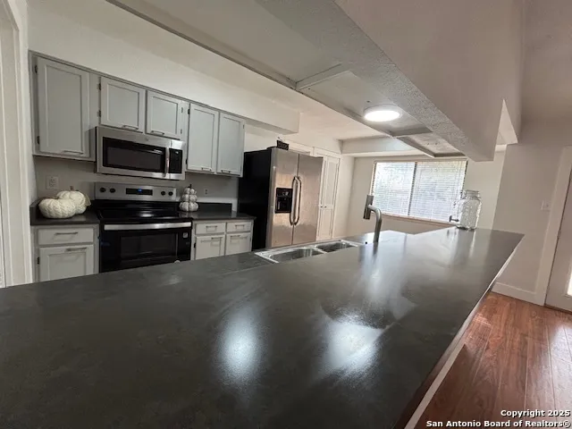 a kitchen with stainless steel appliances granite countertop a stove refrigerator and a microwave
