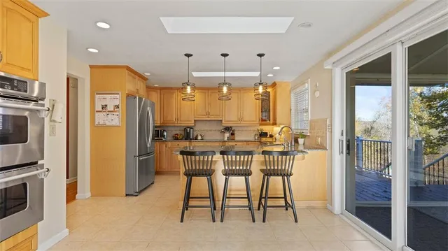 a view of a dining room with furniture a chandelier and kitchen view