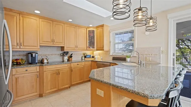 a kitchen with stainless steel appliances granite countertop a sink a stove and cabinets