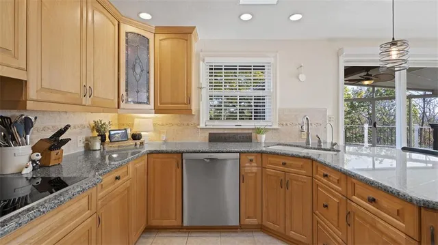 a kitchen with stainless steel appliances granite countertop a sink stove and cabinets