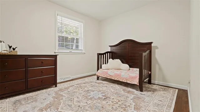 a bed sitting in a bedroom next to a window and a dresser
