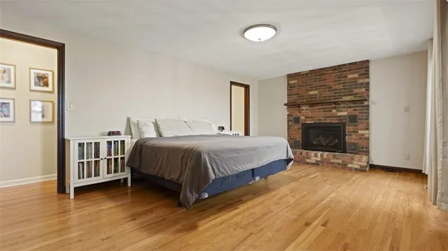 a spacious bedroom with a bed and a fireplace