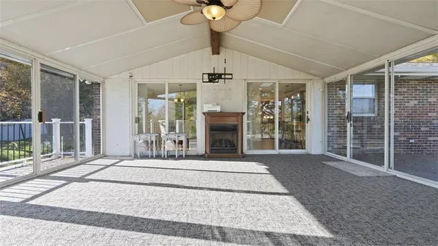 a view of a hall with floor to ceiling windows and a chandelier