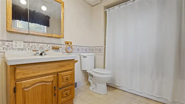a bathroom with a sink a toilet and mirror