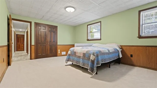 a bedroom with a bed and painting on the wall