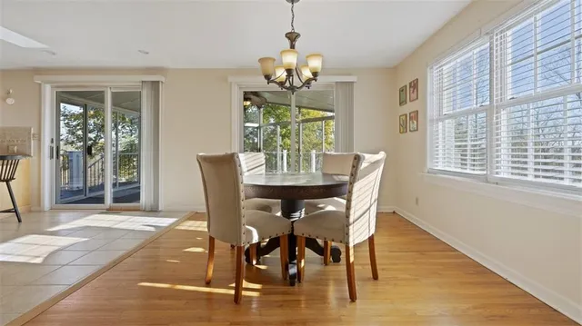 a dining room with furniture a chandelier and wooden floor